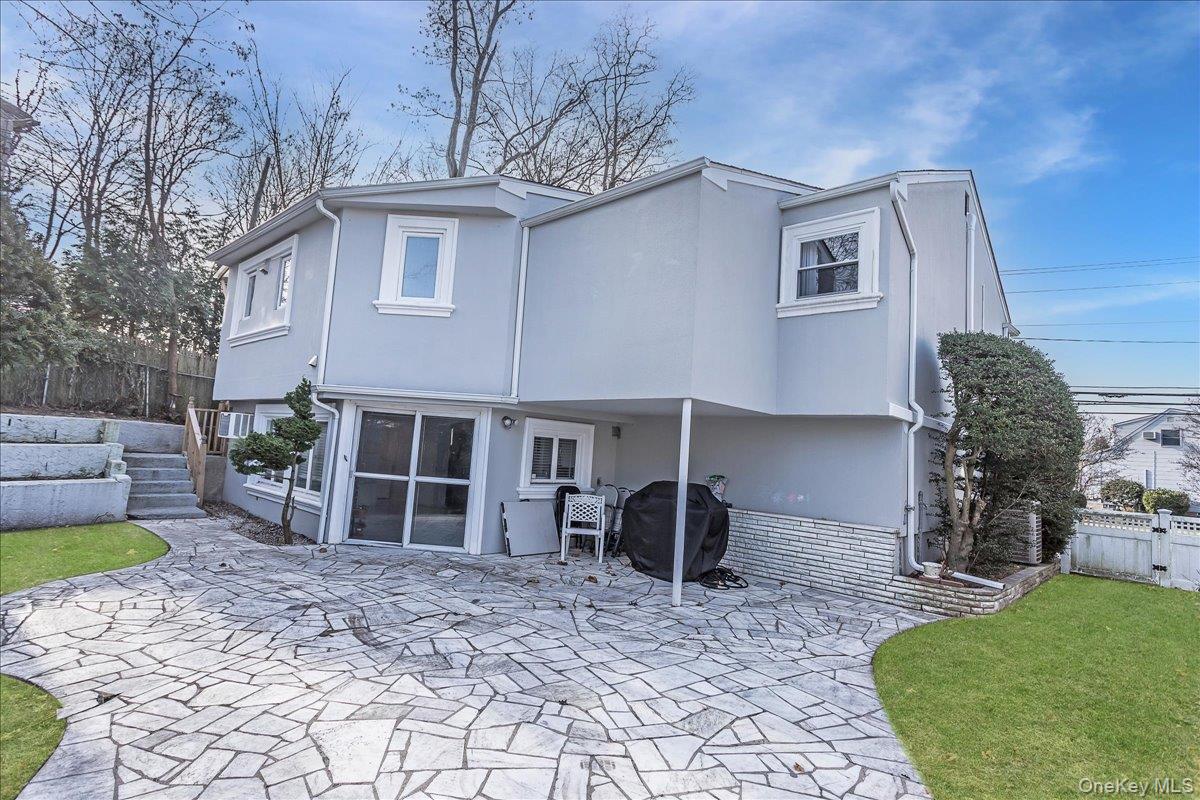 93 Searingtown Road Albertson, NY 11507 - Photo 21 of 24 Rear view of house featuring a patio area, stairs, and stucco siding