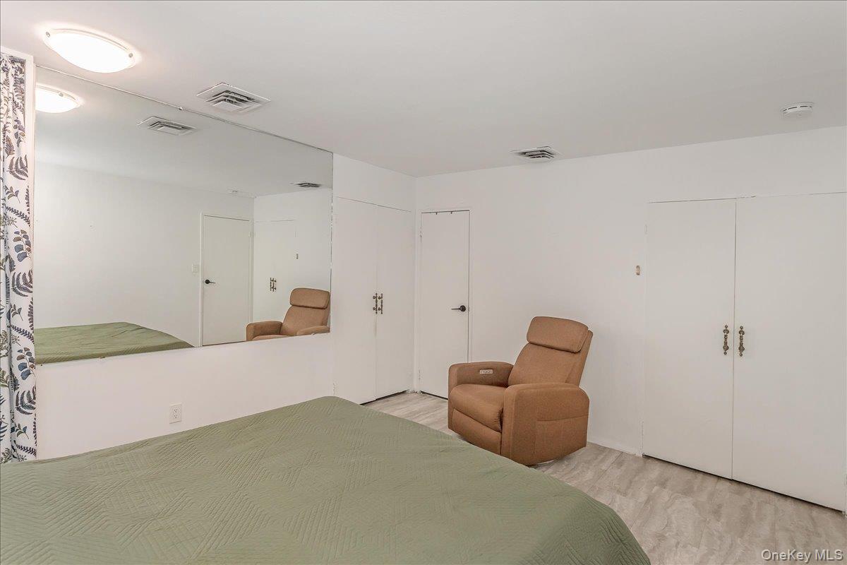 93 Searingtown Road Albertson, NY 11507 - Photo 8 of 24 Bedroom with wood finished floors and multiple closets