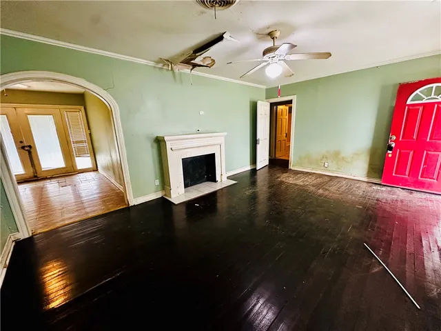 a view of an empty room with window and wooden floor