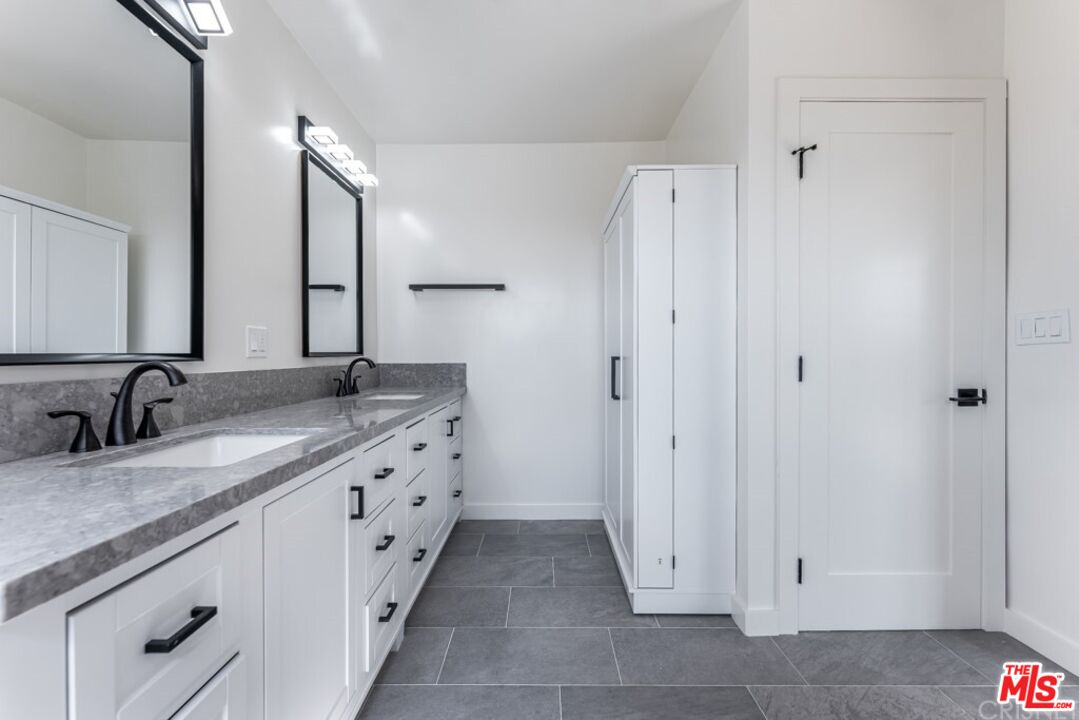 1177 Aztec Topanga, CA 90290 - Photo 23 of 43 a spacious bathroom with a granite countertop sink and a mirror