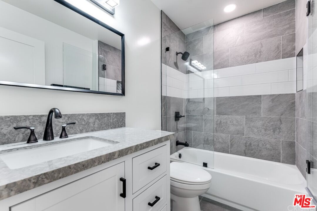 1177 Aztec Topanga, CA 90290 - Photo 29 of 43 a bathroom with a granite countertop sink a toilet a mirror and bathtub