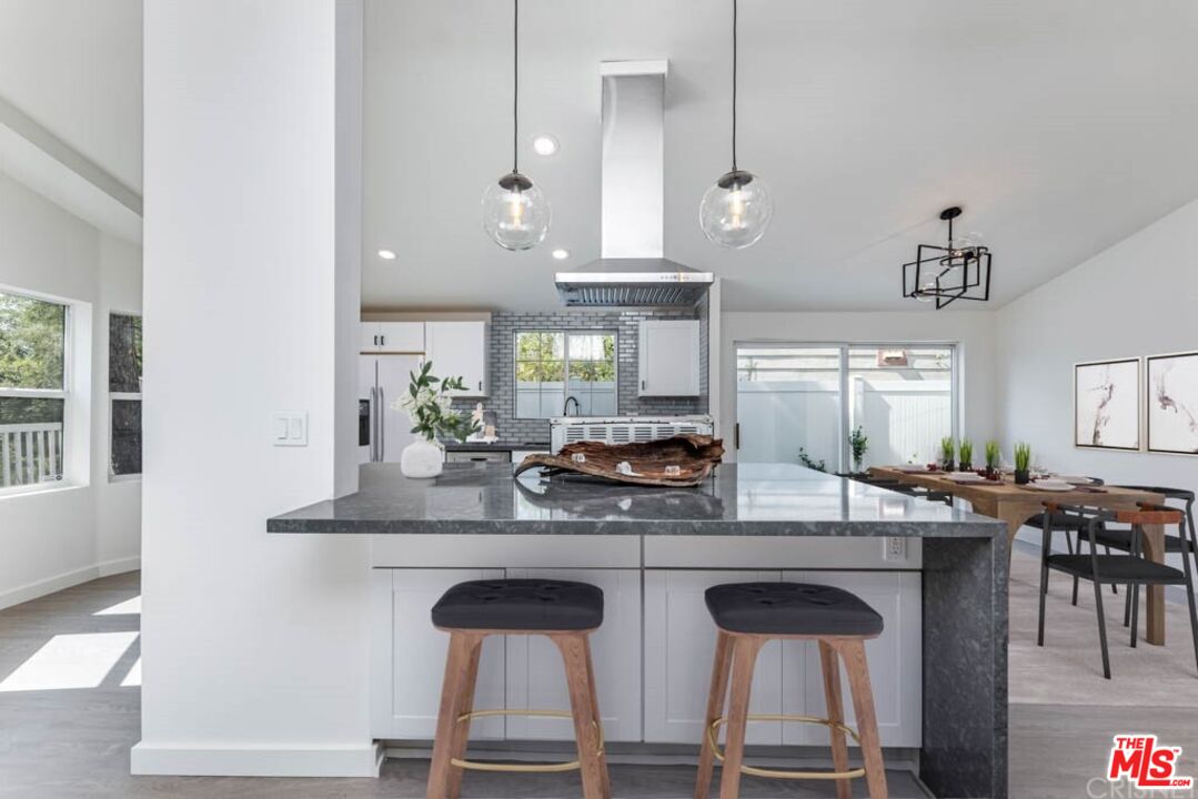1177 Aztec Topanga, CA 90290 - Photo 7 of 43 a kitchen with kitchen island granite countertop a table chairs sink and window