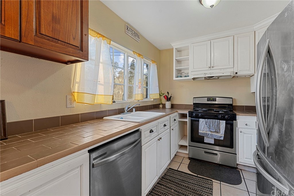 5005 Pearblossom Drive Riverside, CA 92507 - Photo 7 of 19 a kitchen with stainless steel appliances granite countertop a sink stove and refrigerator
