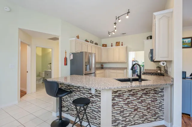 a kitchen with stainless steel appliances granite countertop a sink and a refrigerator