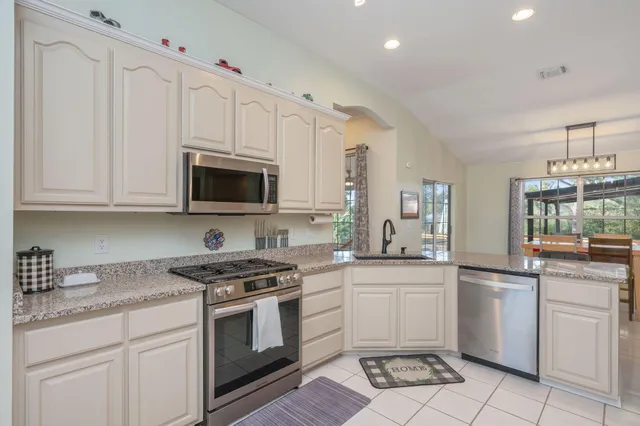 a kitchen with white cabinets stainless steel appliances and sink