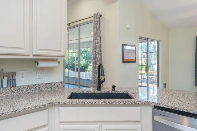 a kitchen with granite countertop a window and a white counter space