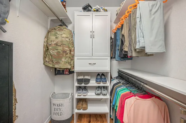 a view of walk in closet with clothes and shoes
