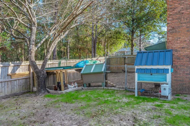 a view of backyard with wooden fence and a large tree
