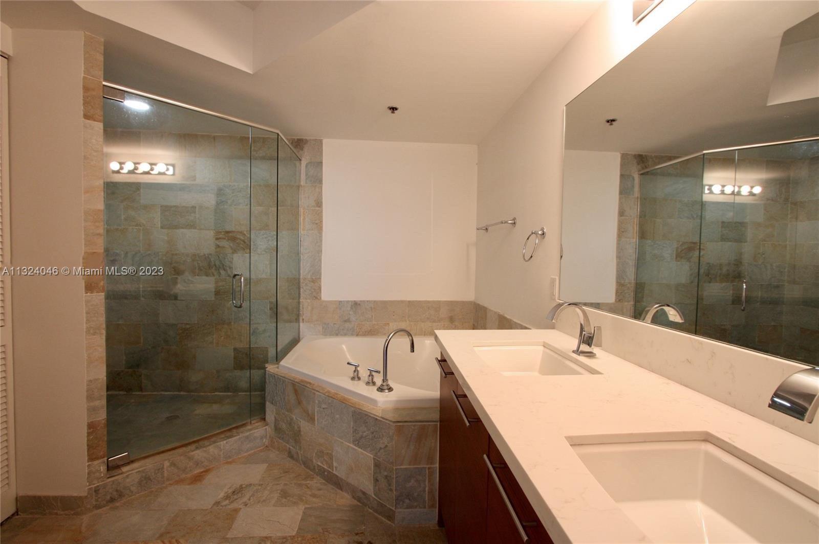 2681 North Flamingo Road, Unit 506S Sunrise, FL 33323 - Photo 8 of 20 a bathroom with a tub sink shower and mirror