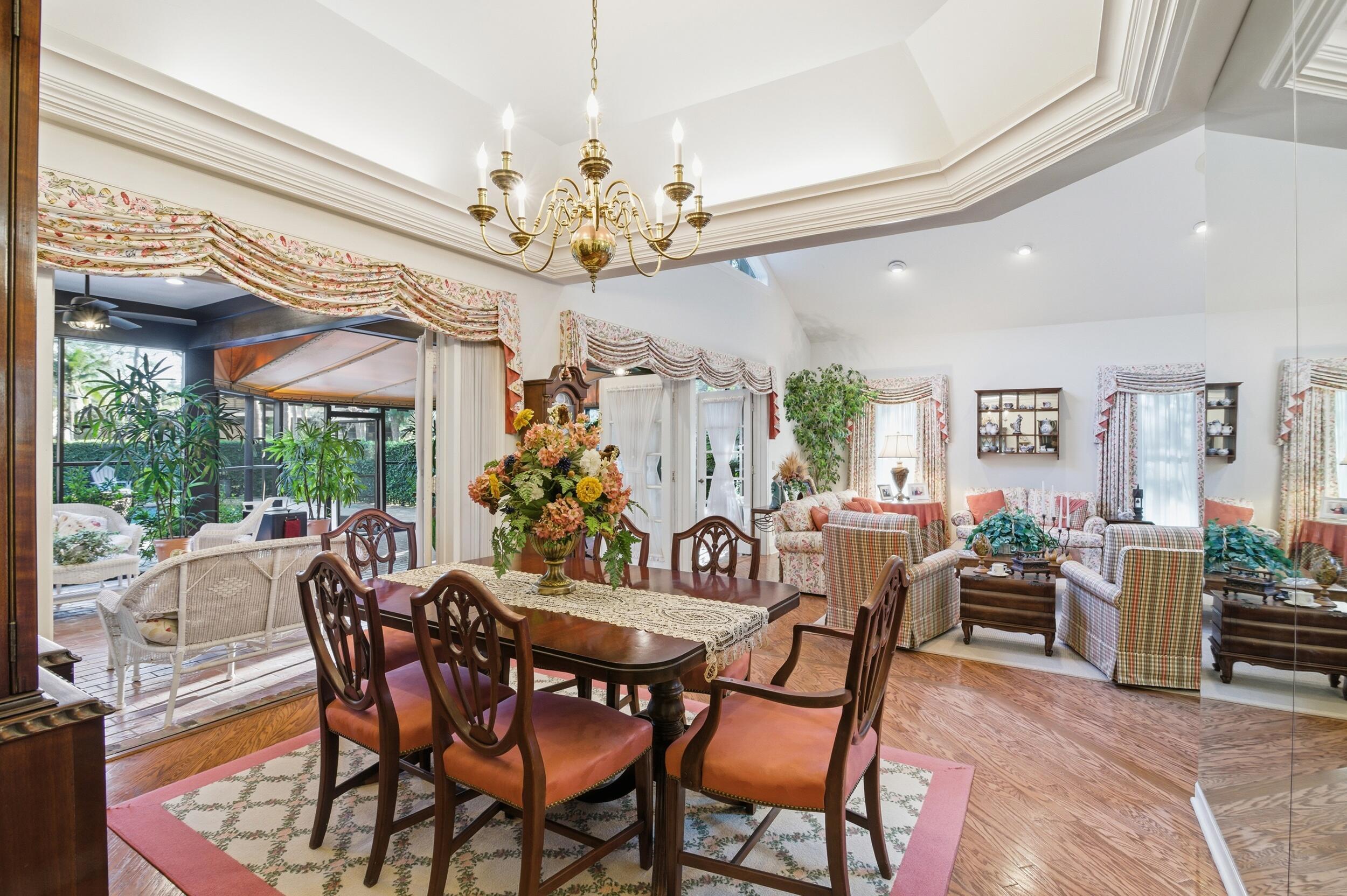 4838 Charlton Way Delray Beach, FL 33484 - Photo 21 of 74 a view of a dining room with furniture a chandelier and large windows
