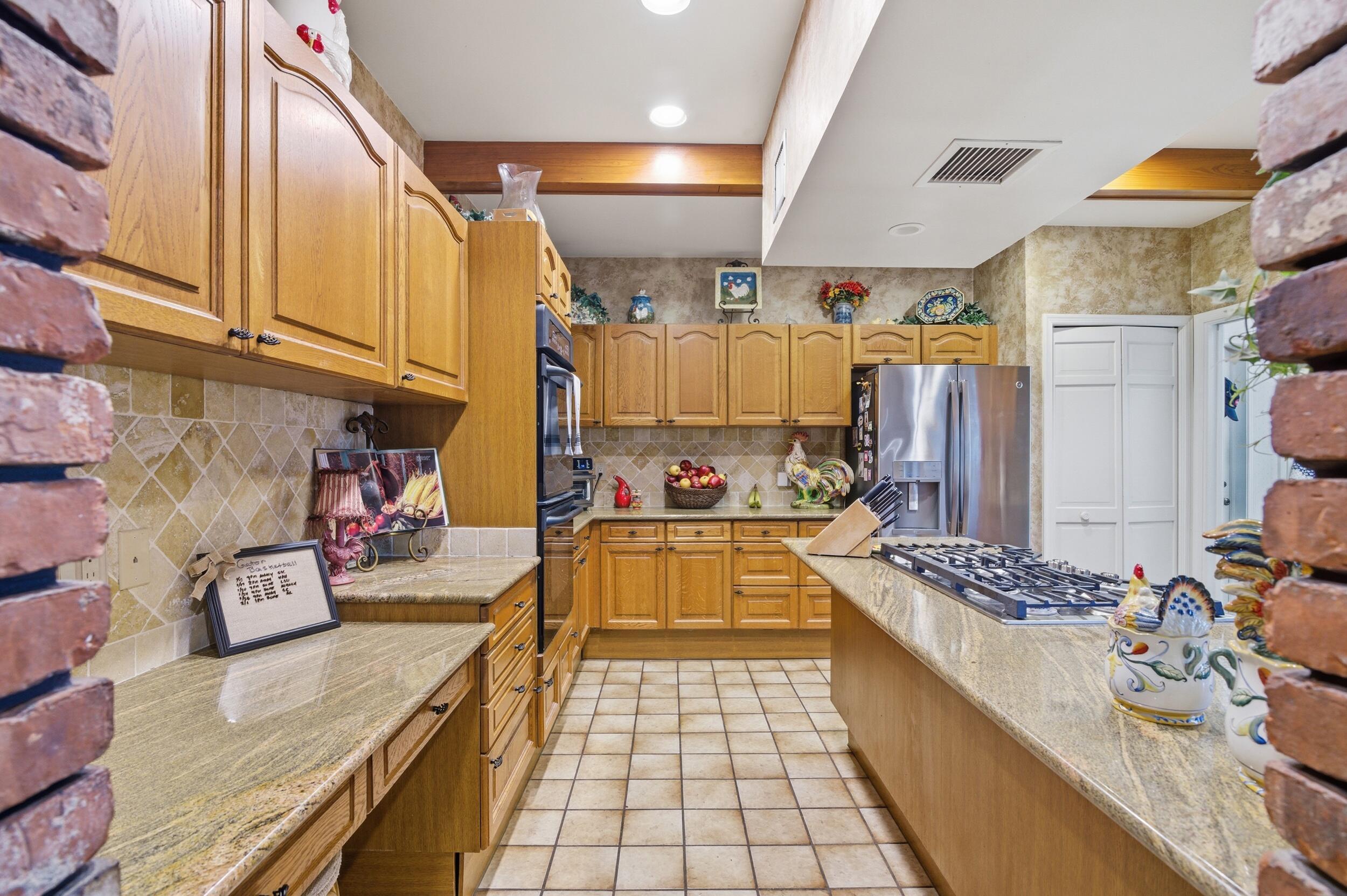 4838 Charlton Way Delray Beach, FL 33484 - Photo 27 of 74 a large white kitchen with stainless steel appliances granite countertop a stove and a refrigerator