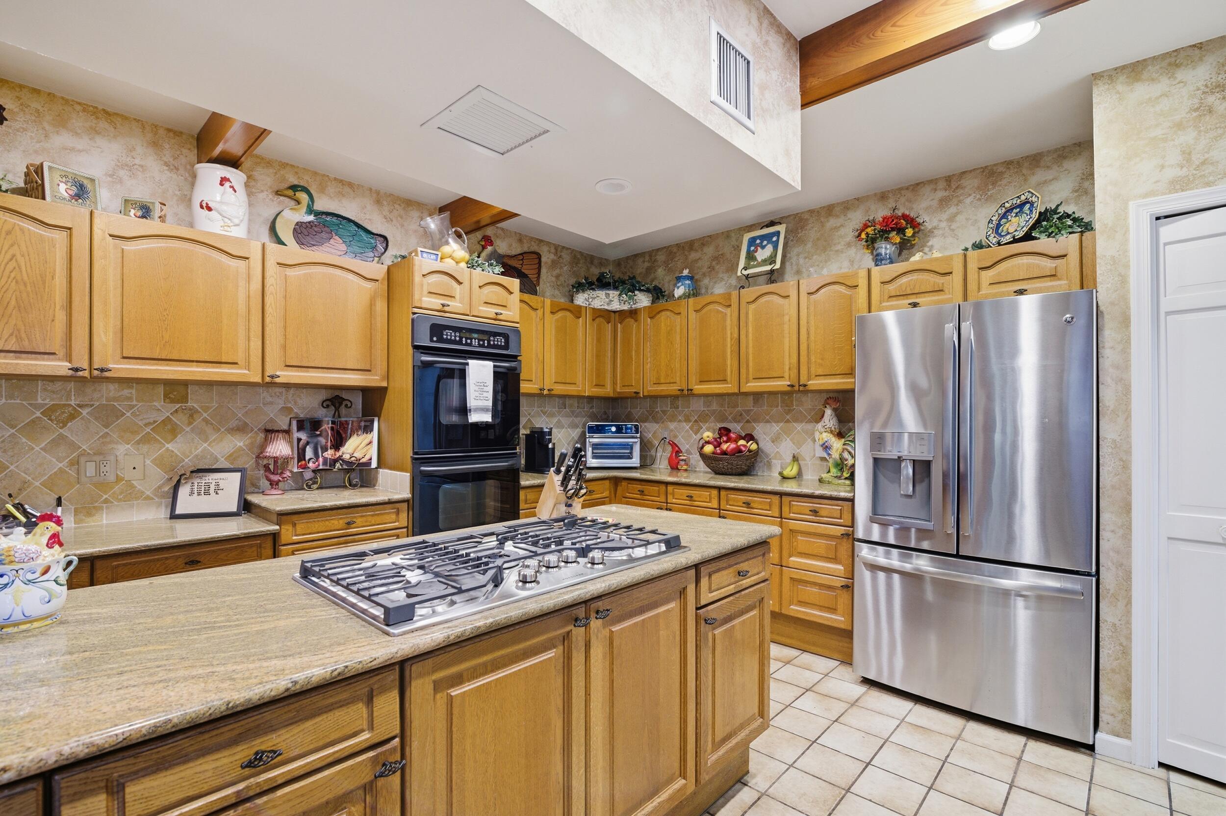 4838 Charlton Way Delray Beach, FL 33484 - Photo 29 of 74 a kitchen with stainless steel appliances granite countertop a refrigerator a sink and white cabinets