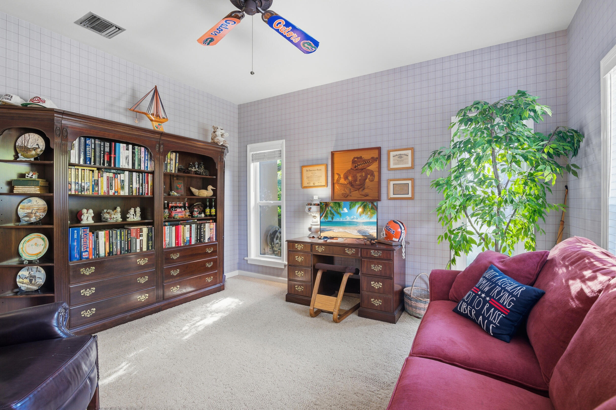 4838 Charlton Way Delray Beach, FL 33484 - Photo 35 of 74 a living room with furniture a bookshelf and a potted plant