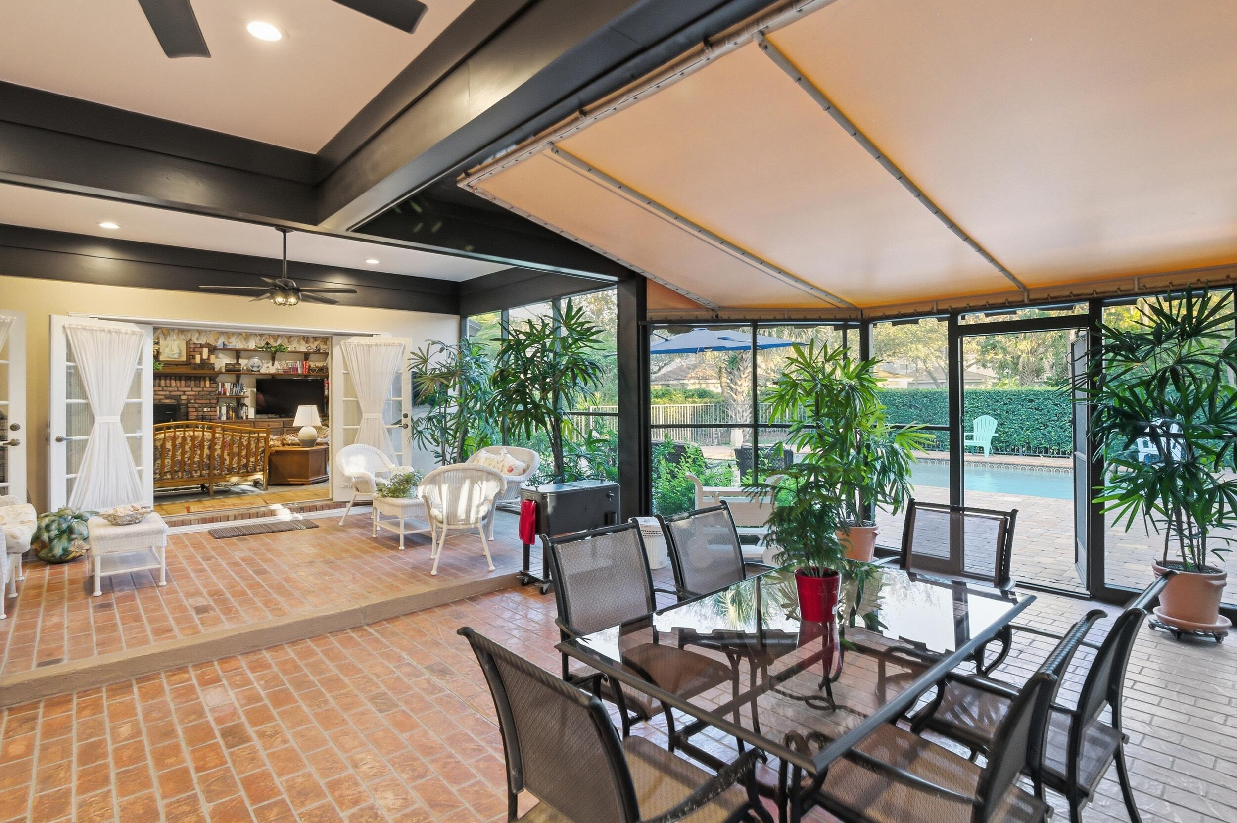 4838 Charlton Way Delray Beach, FL 33484 - Photo 58 of 74 a dining room with furniture large windows and garden view