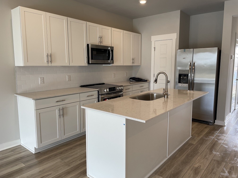 385 Casper Drive Spring Hill, TN 37174 - Photo 3 of 23 a kitchen with a sink a stove and refrigerator