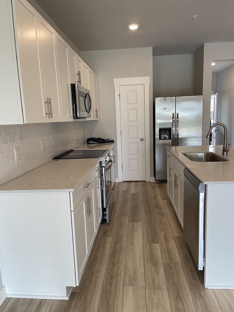 385 Casper Drive Spring Hill, TN 37174 - Photo 4 of 23 a kitchen with stainless steel appliances granite countertop a stove and a sink