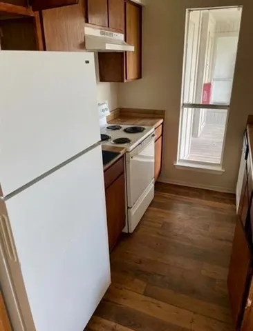 a utility room with wooden floor washer and dryer