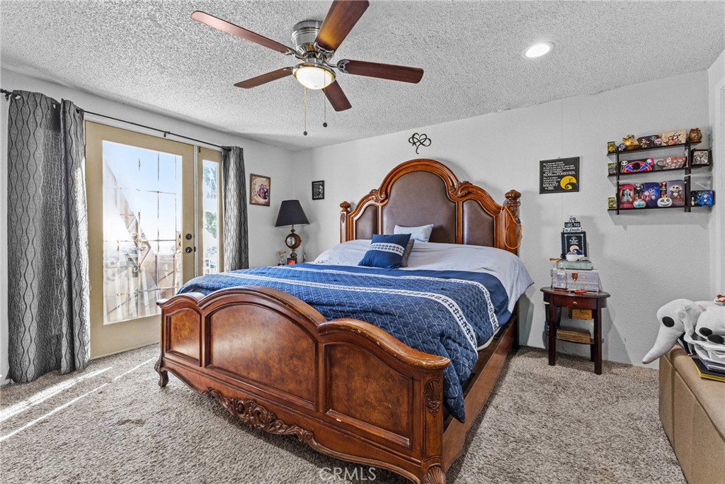 33945 Red Mountain Road Hemet, CA 92544 - Photo 13 of 30 a bedroom with a bed and a chandelier