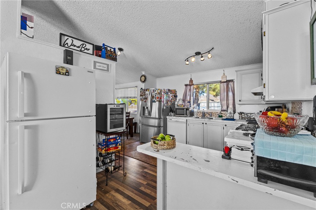 33945 Red Mountain Road Hemet, CA 92544 - Photo 22 of 30 a white kitchen with a refrigerator and a sink