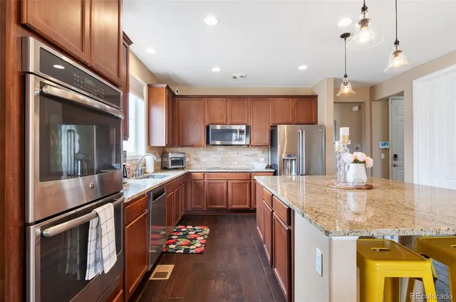 a kitchen with granite countertop a sink stove and refrigerator