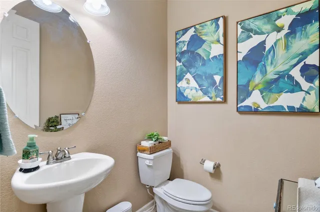 a bathroom with a toilet a sink and mirror