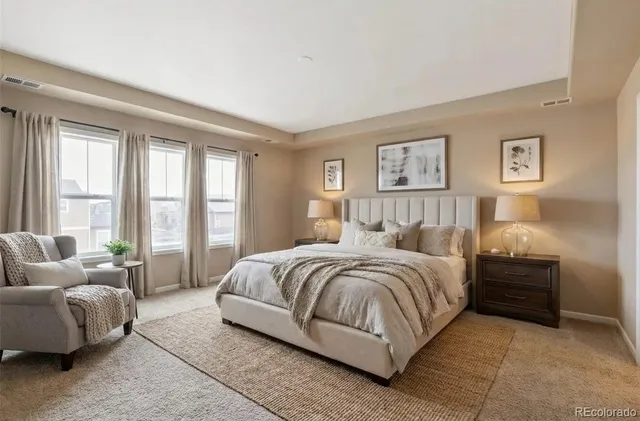 a spacious bedroom with a bed and glass window