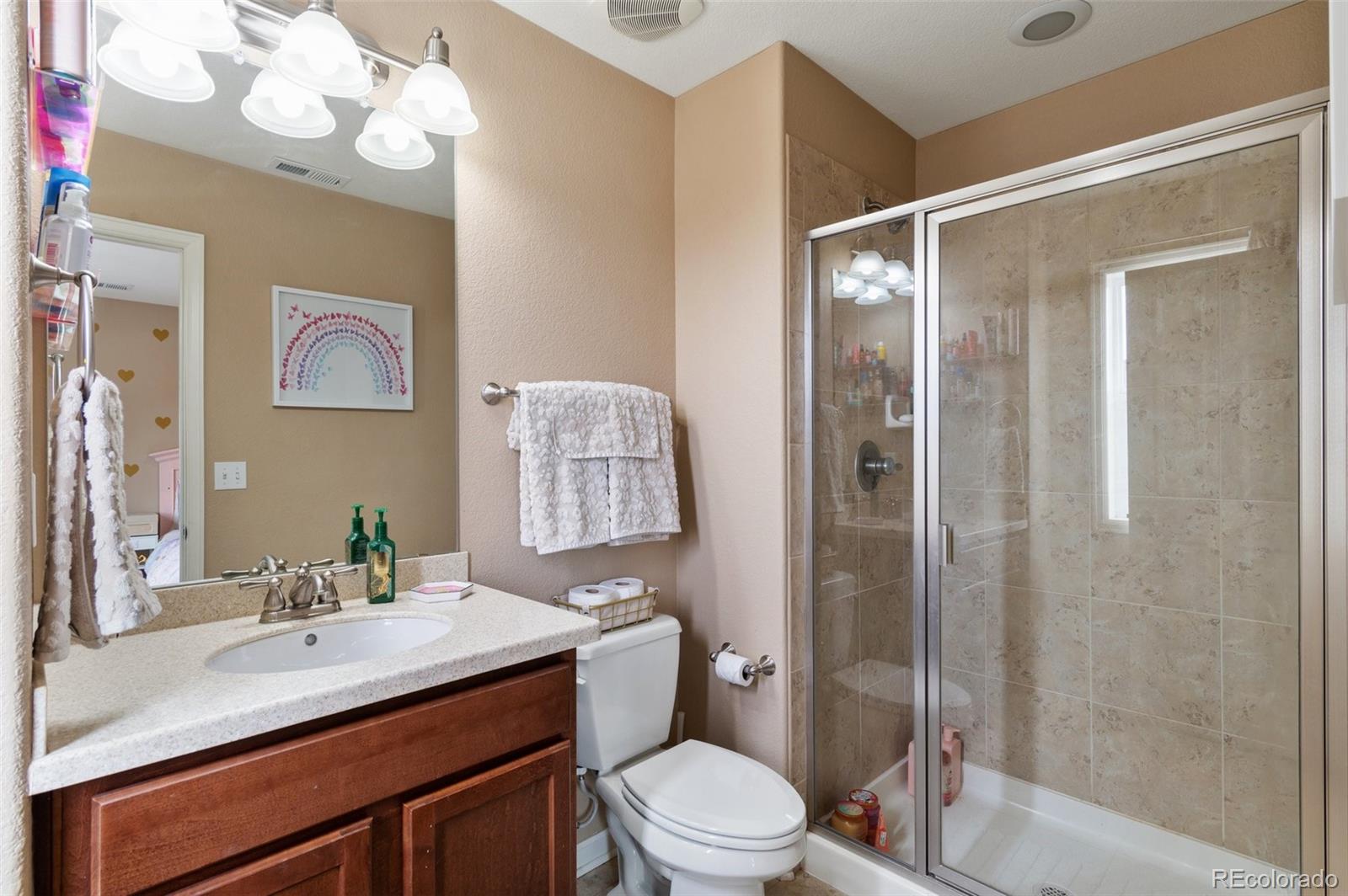 10995 Quintero Street Commerce City, CO 80022 - Photo 24 of 41 a bathroom with a sink vanity mirror and toilet