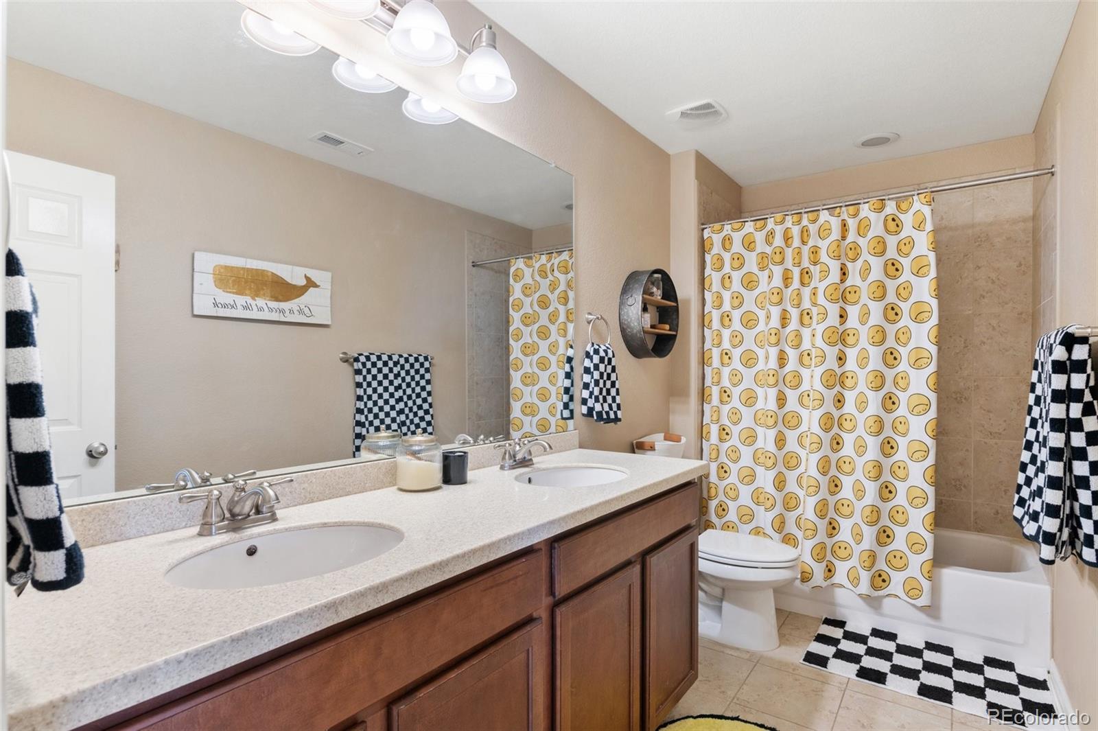 10995 Quintero Street Commerce City, CO 80022 - Photo 27 of 41 a bathroom with a sink a toilet and a large mirror
