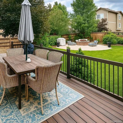 a view of a patio with a table chairs and a barbeque