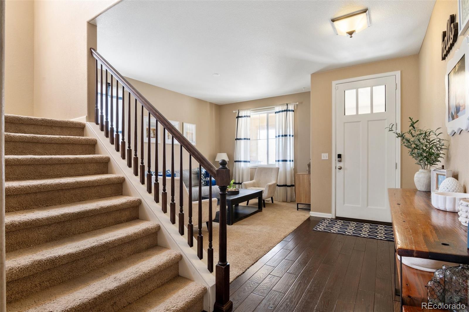 10995 Quintero Street Commerce City, CO 80022 - Photo 7 of 41 a view of a hallway with wooden floor and stairs