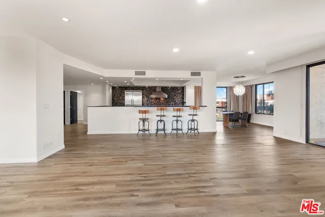 a view of a living room and kitchen with furniture and wooden floor