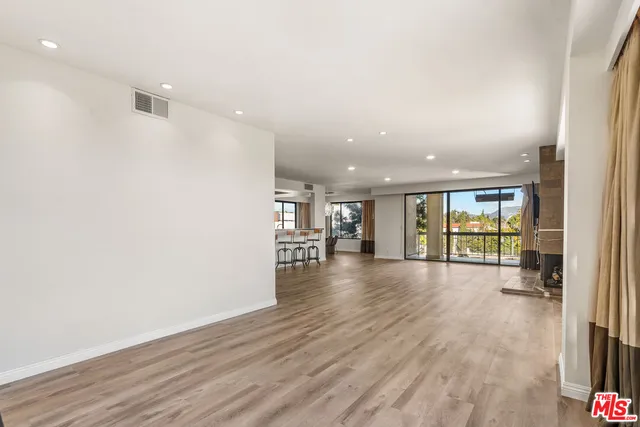 a view of a dining room with furniture large windows and wooden floor