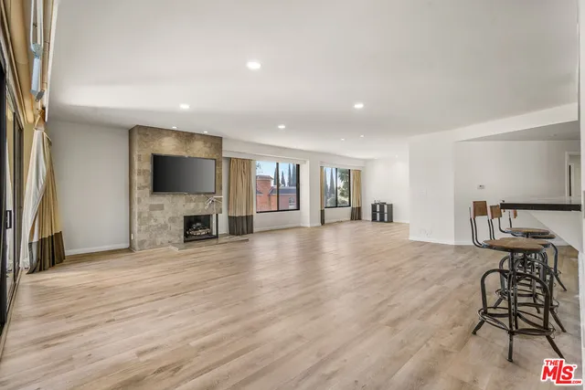 a kitchen with stainless steel appliances kitchen island granite countertop a dining table and chairs with wooden floor