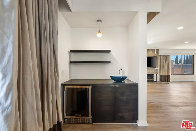 a kitchen with stainless steel appliances granite countertop a large stove top oven a chimney wooden floor and cabinets