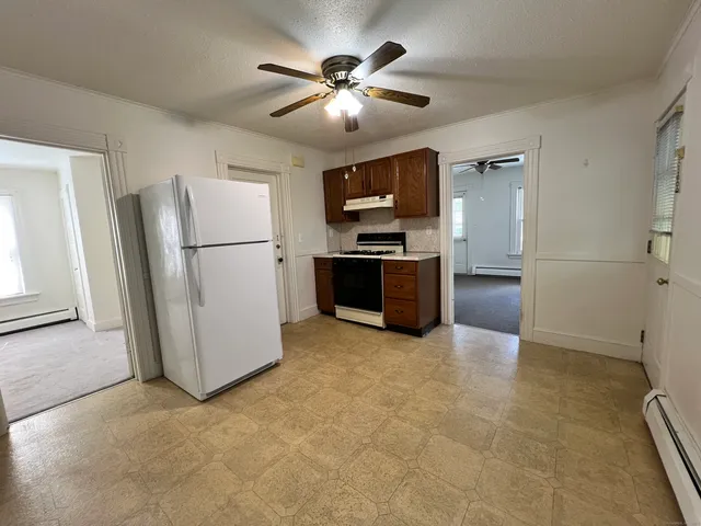 a view of kitchen with furniture and refrigerator