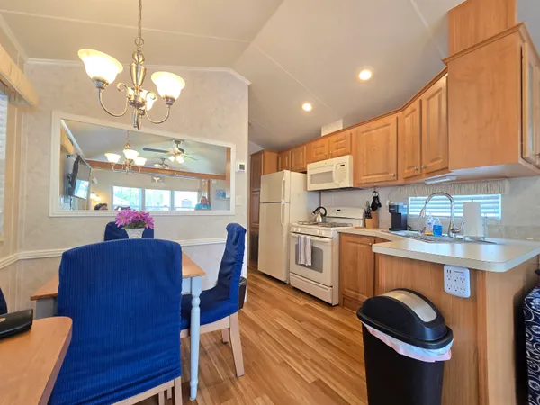 a kitchen with a dining table chairs stainless steel appliances and cabinets