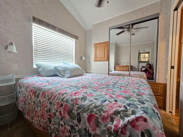 a bedroom with a large bed and a chandelier