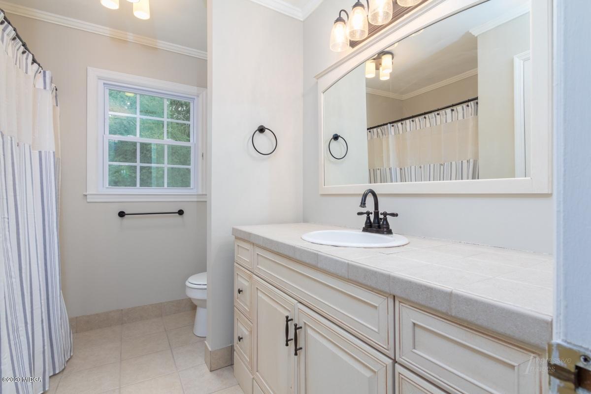 502 Stone Edge Road Macon, GA 31210 - Photo 14 of 22 a bathroom with a sink a toilet and a window
