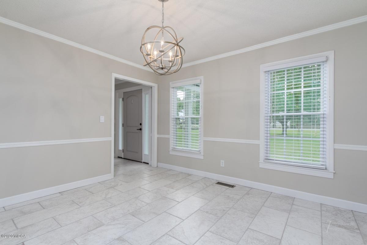 502 Stone Edge Road Macon, GA 31210 - Photo 3 of 22 an empty room with chandelier and windows