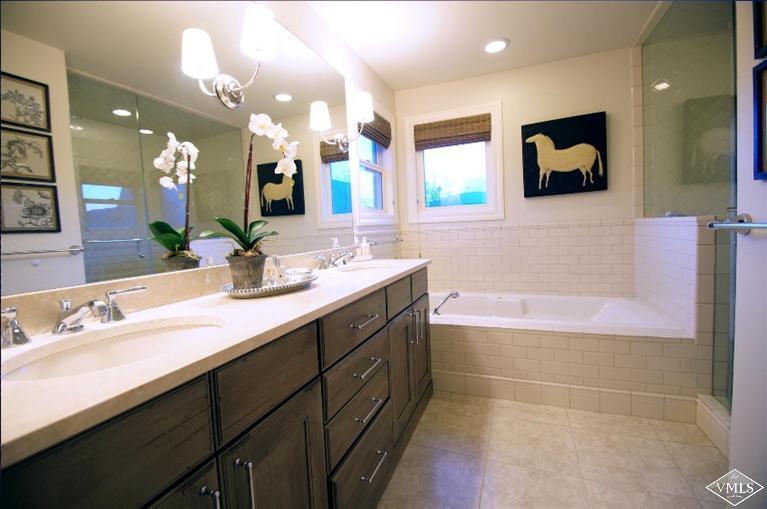 79 Cassidy Place Edwards, CO 81632 - Photo 5 of 8 a bathroom with a double vanity sink a mirror and a bathtub