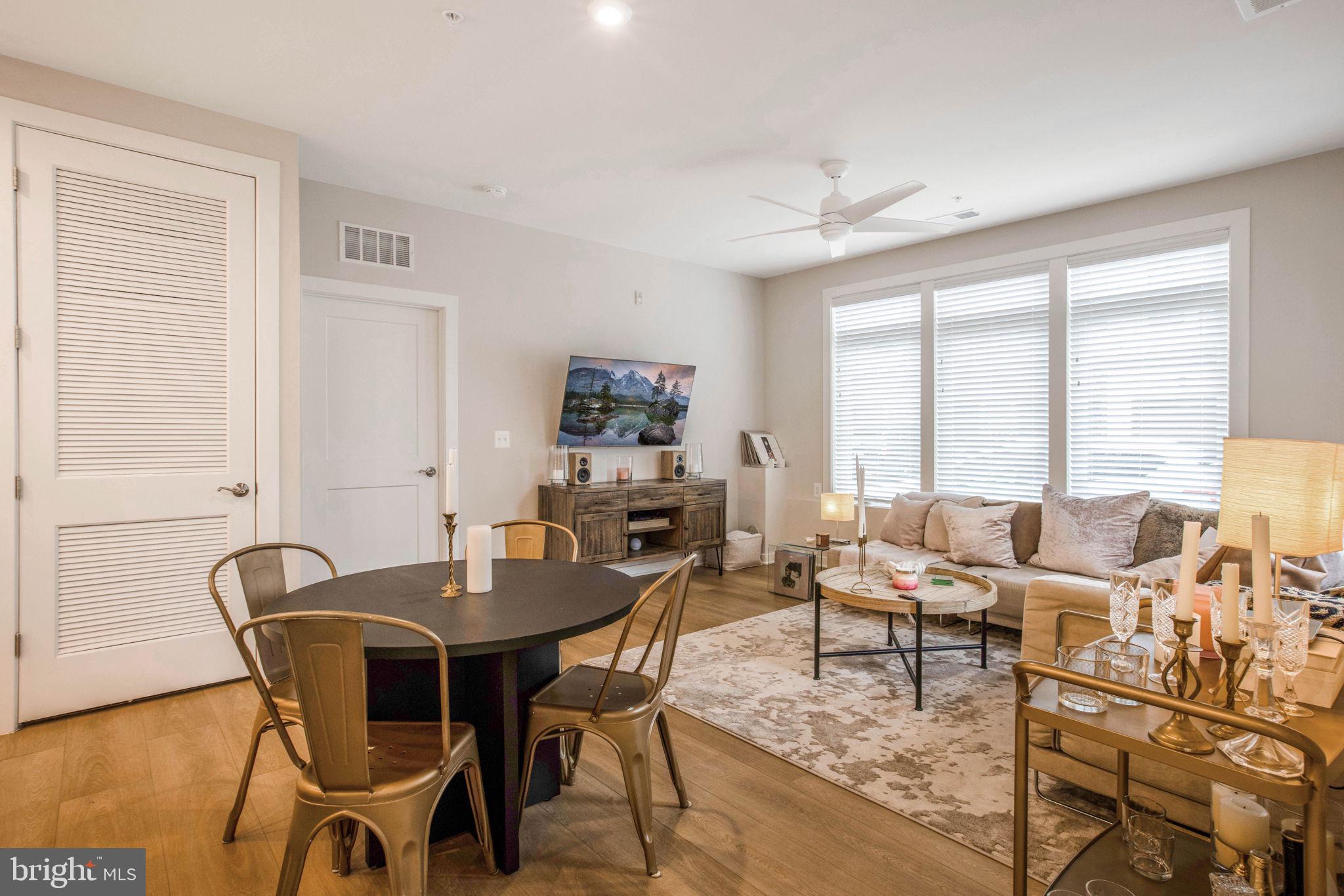 1669 Bandit Loop, Unit 107A Reston, VA 20190 - Photo 12 of 30 a dining room with furniture a chandelier and wooden floor