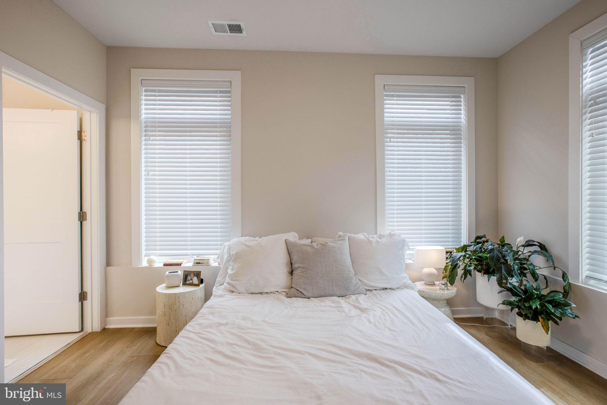 1669 Bandit Loop, Unit 107A Reston, VA 20190 - Photo 13 of 30 a bedroom with a bed and a potted plant