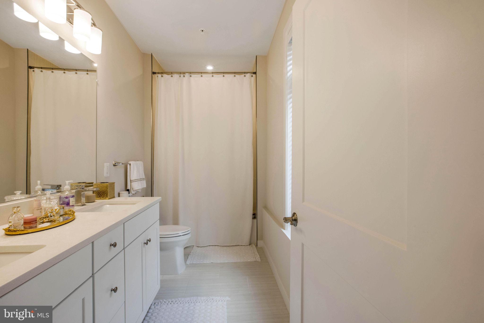 1669 Bandit Loop, Unit 107A Reston, VA 20190 - Photo 17 of 30 a bathroom with a double vanity sink and mirror