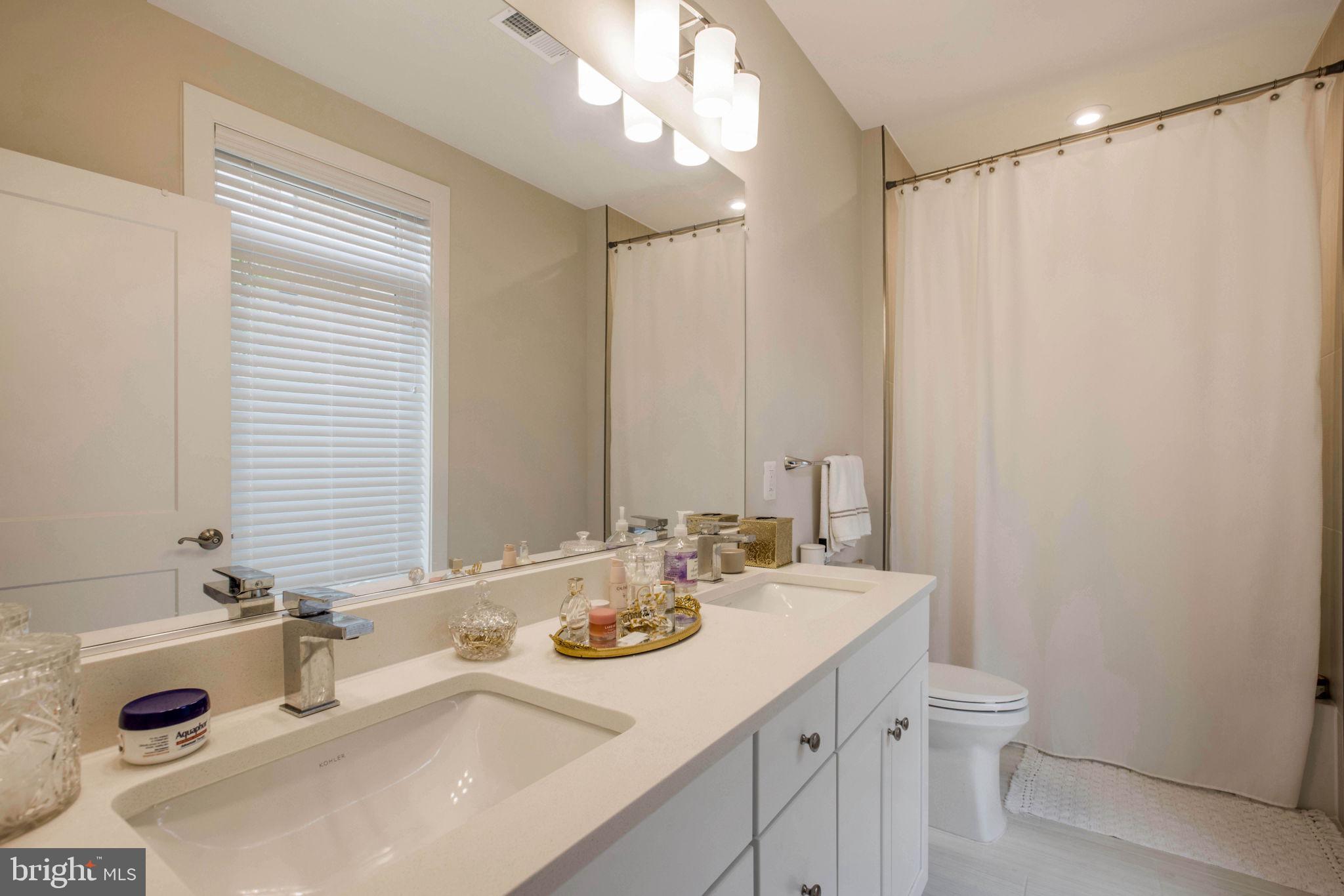 1669 Bandit Loop, Unit 107A Reston, VA 20190 - Photo 18 of 30 a bathroom with a sink double vanity and a mirror