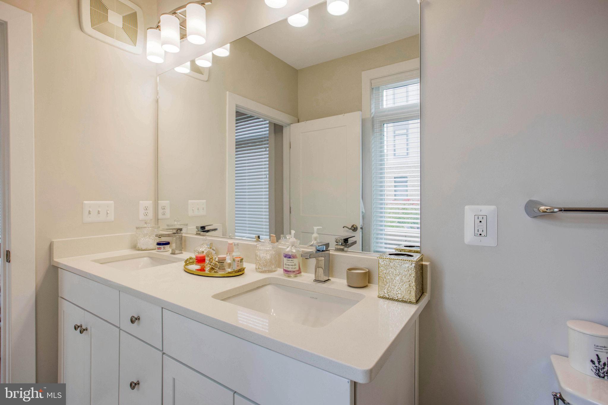1669 Bandit Loop, Unit 107A Reston, VA 20190 - Photo 20 of 30 a bathroom with a sink a toilet and a mirror