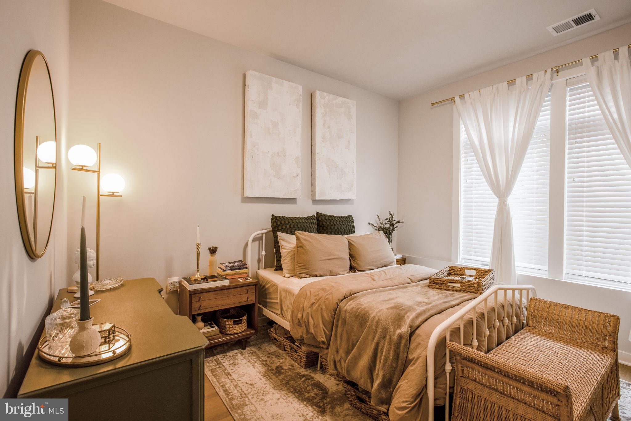 1669 Bandit Loop, Unit 107A Reston, VA 20190 - Photo 22 of 30 a bedroom with a bed and a mirror