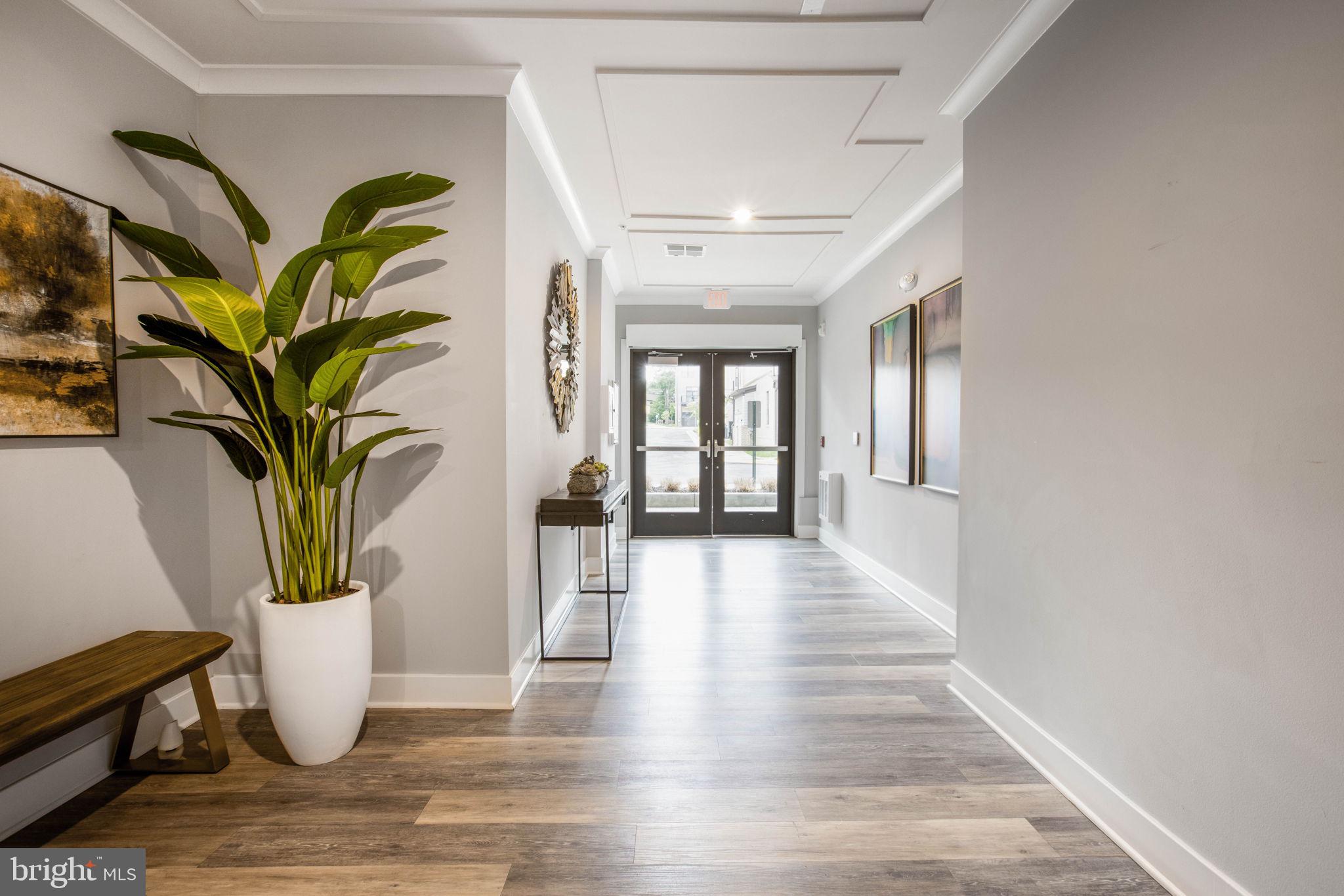 1669 Bandit Loop, Unit 107A Reston, VA 20190 - Photo 29 of 30 a view of a hallway with wooden floor and a potted plant