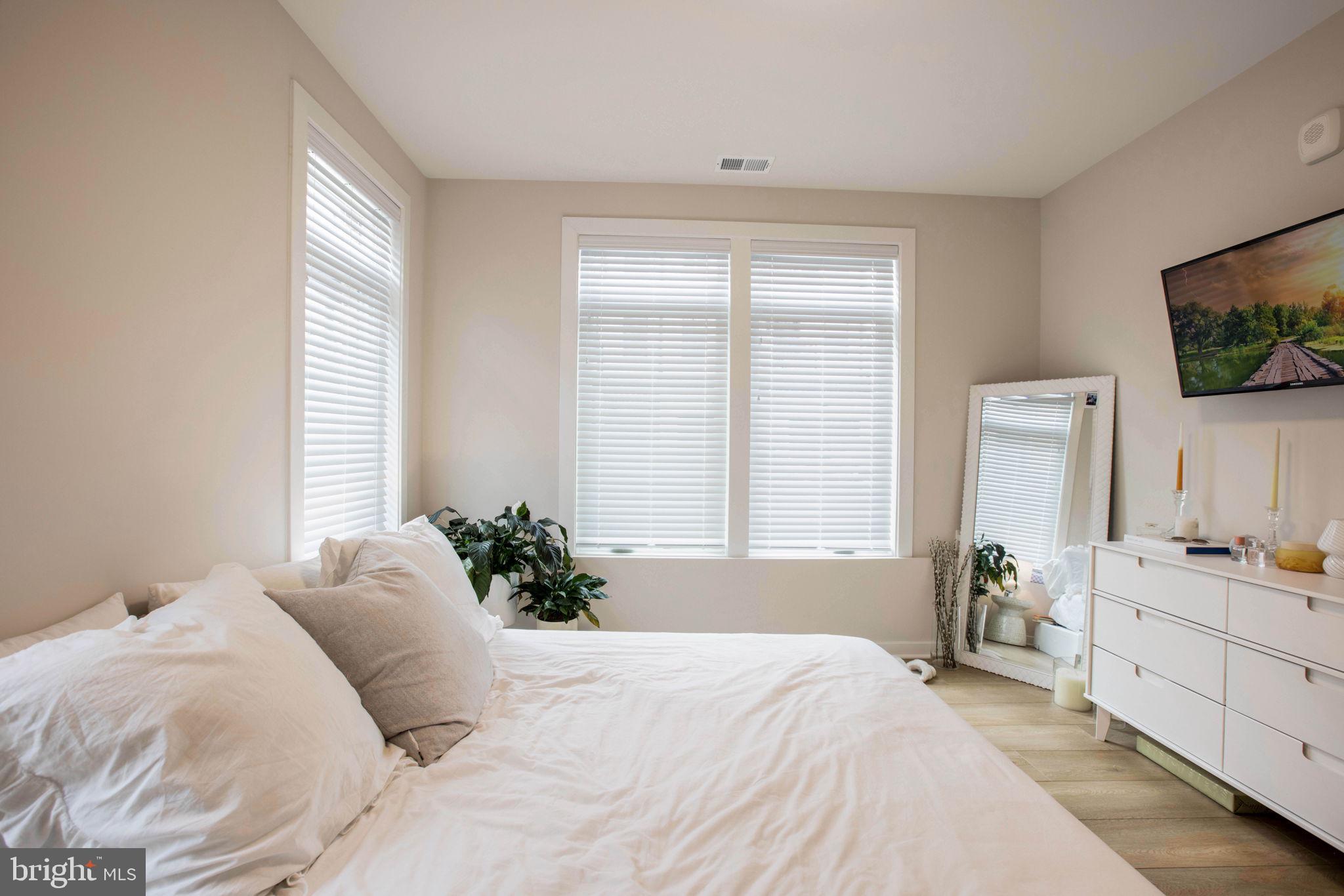 1669 Bandit Loop, Unit 107A Reston, VA 20190 - Photo 4 of 30 a bedroom with a bed and a flat screen tv