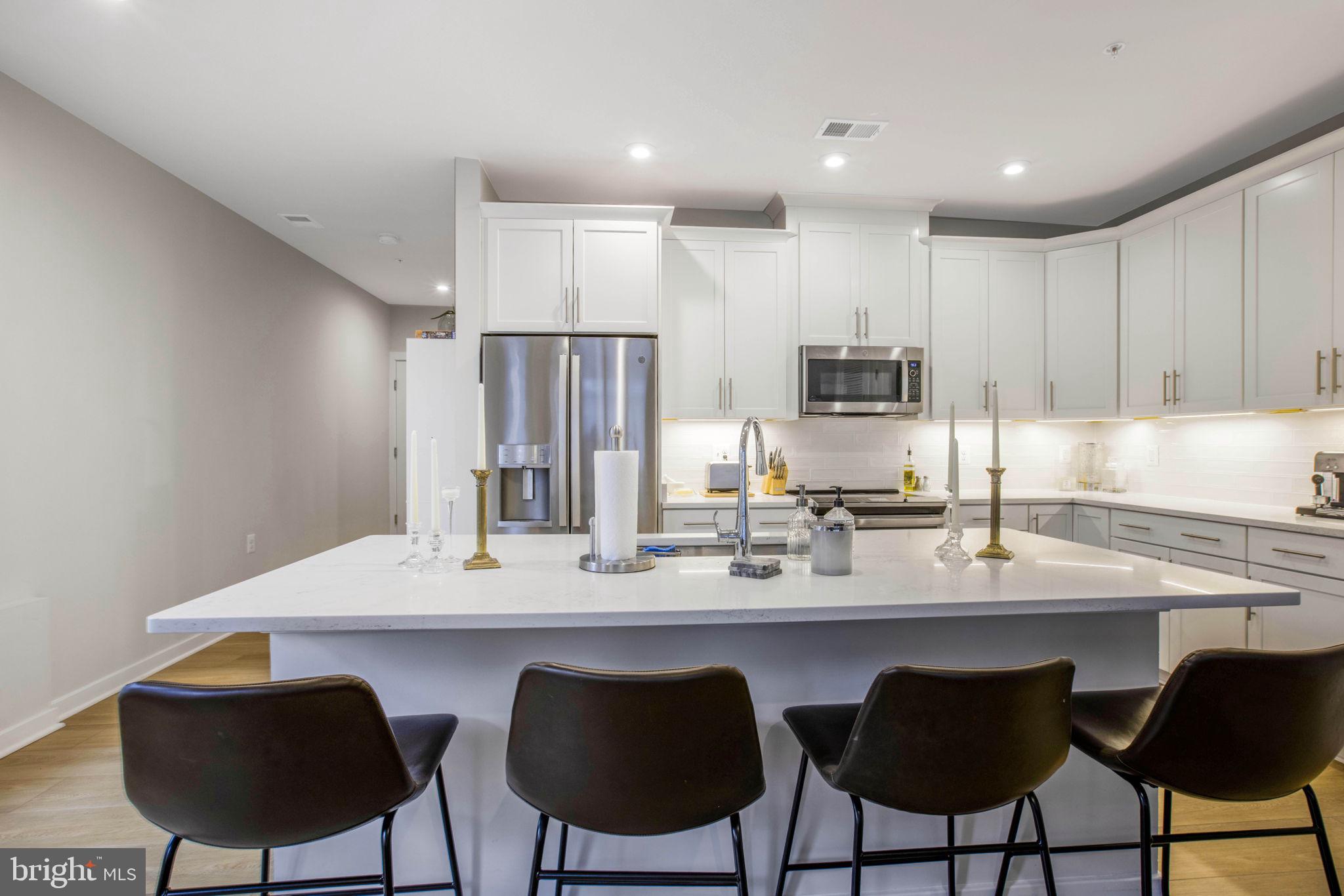 1669 Bandit Loop, Unit 107A Reston, VA 20190 - Photo 9 of 30 a kitchen with a dining table chairs and refrigerator