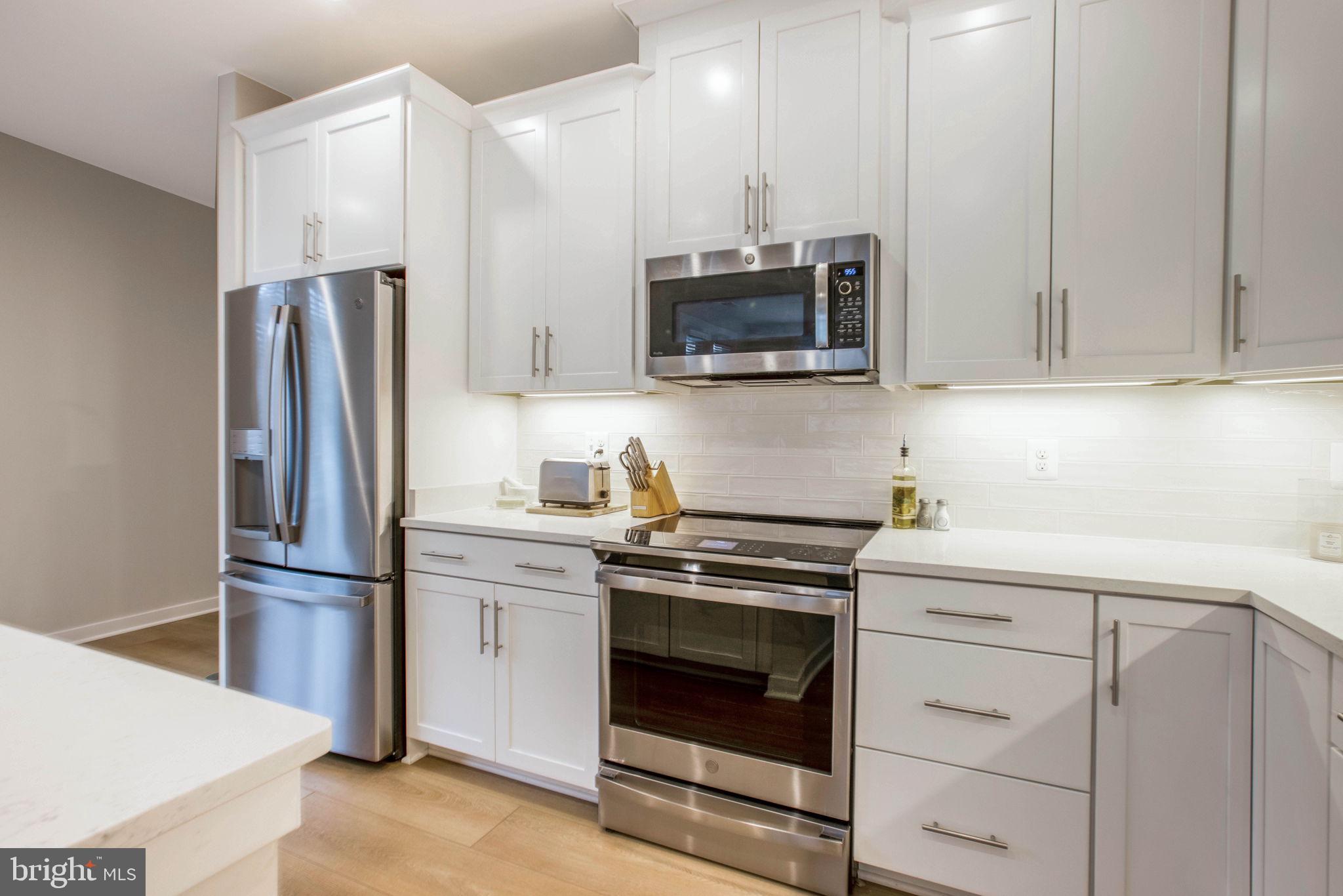 1669 Bandit Loop, Unit 107A Reston, VA 20190 - Photo 10 of 30 a kitchen with stainless steel appliances white cabinets and a stove